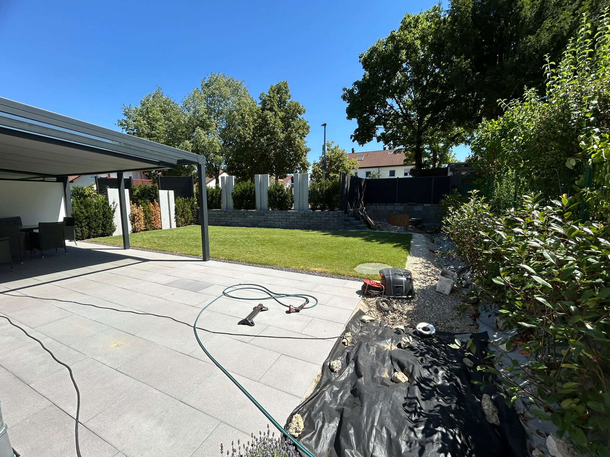 Nachher: fertig angelegter Garten mit Rasen, Buchsbaumkugeln und Terrasse